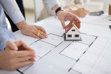 Poster - architecture, construction business and people concept - close up of architects with blueprint discussing house project at office