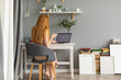 © Javier Pardina/Stocksy - Redhead woman working at home