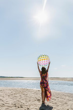 Woman Lifting Beach Ball On Lovely Summer Day
