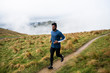 © Thomas Pickard Photography Ltd/Stocksy - Athletic man jogging along a dirt path in the mountains.