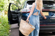 © jamie grill photography/Stocksy - Woman packing car for road trip