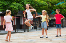 Kids In School Age Playing Together With Jumping Rope