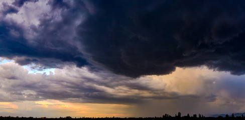 Wall Mural - dramatic light through the clouds against the backdrop of an exciting, bright stormy sky at sunset. 