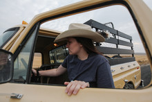 Cowgirl Getting Into Driver's Side Of Old Pickup