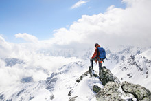 Mountaineer On The Top Of A Mountain In The Background Of The Landscape Of Snowy Mountains