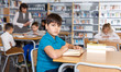 © JackF - Tween boy reading textbooks in school library