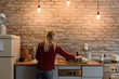 © Milles Studio/Stocksy - Woman cooking at counter in cozy kitchen