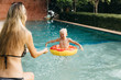 © Andrey Pavlov/Stocksy - Mom and son having fun in the swimming pool
