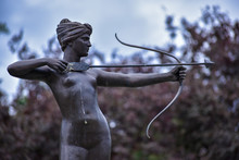 Statue Of The Naked Lady Who Is Holding A Bow And Arrow And Aiming For Target