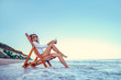 Pretty woman relaxing on a lounger beach and drinks soda water. summer vacation concept.