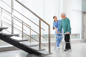 Sticker - Nurse assisting senior man with walker in hospital