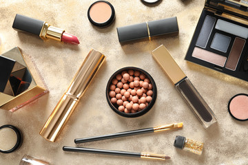 Wall Mural - Different luxury makeup products on gold background, flat lay