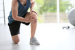 © New Africa - Man in sportswear suffering from knee pain at gym, closeup