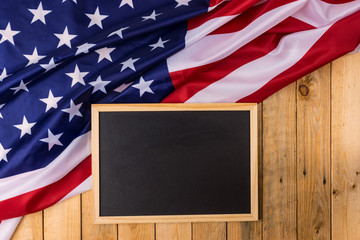 Wall Mural - Flag of the United States of America with chalkboard on wooden background. USA holiday of Veterans, Memorial, Independence and Labor Day.