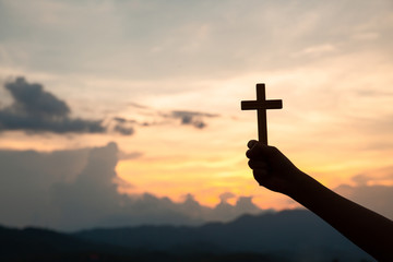 Hands holding wooden cross  on sky background, Crucifix, Symbol of Faith.