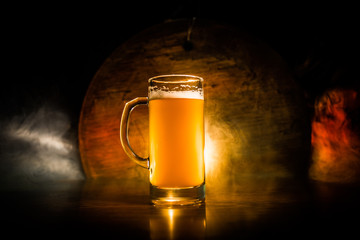 Creative concept. Beer glasses on wooden table at dark toned foggy background.