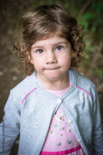 Portrait Of A Cute Curly Haired Girl With Beautiful Brown Eyes