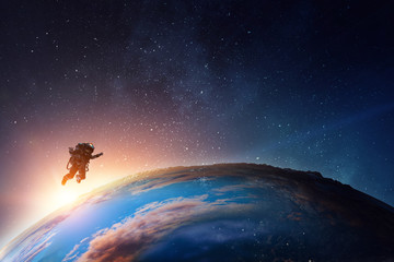 Wall Mural - astronaut in space on planet orbit.