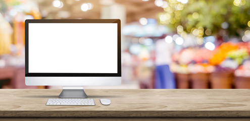 Wall Mural - blank screen desktop computer on wooden table top with blur people shopping at supermarket bokeh bac