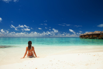 Wall Mural - Young fashion woman relax on the beach. Happy lifestyle. White sand, blue sky and crystal sea of tropical beach. Vacation at Paradise. Ocean beach relax, travel to islands