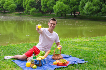 Young happy man picnicking and relaxing outdoors