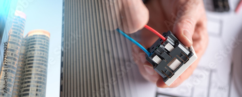 Fotografía Electrician connecting a wire into a power socket; multiple expo