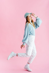 Wall Mural - full length view of smiling pretty teenage girl in cap on pink