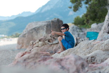 Boy is sitting on the rock