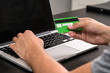 © CrispyMedia - Young business man typing in credit card info on a computer keyb