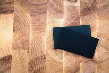 Wall Mural - Photo of black blank business cards on wooden background. Templa