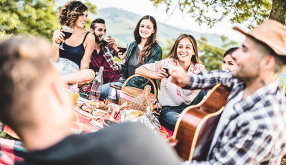 Wall Mural - Happy adult friends eating at picnic lunch in vineyard outdoor - Young people having fun on gastronomic weekend tour - Friendship, summer and food concept - Focus on  center blond girl