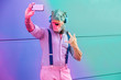 © DisobeyArt - Tattooed man with t-rex mask using smartphone while listening music - Crazy senior male taking selfie with mobile phone app - Radial purple and blue filter editing - Focus on face