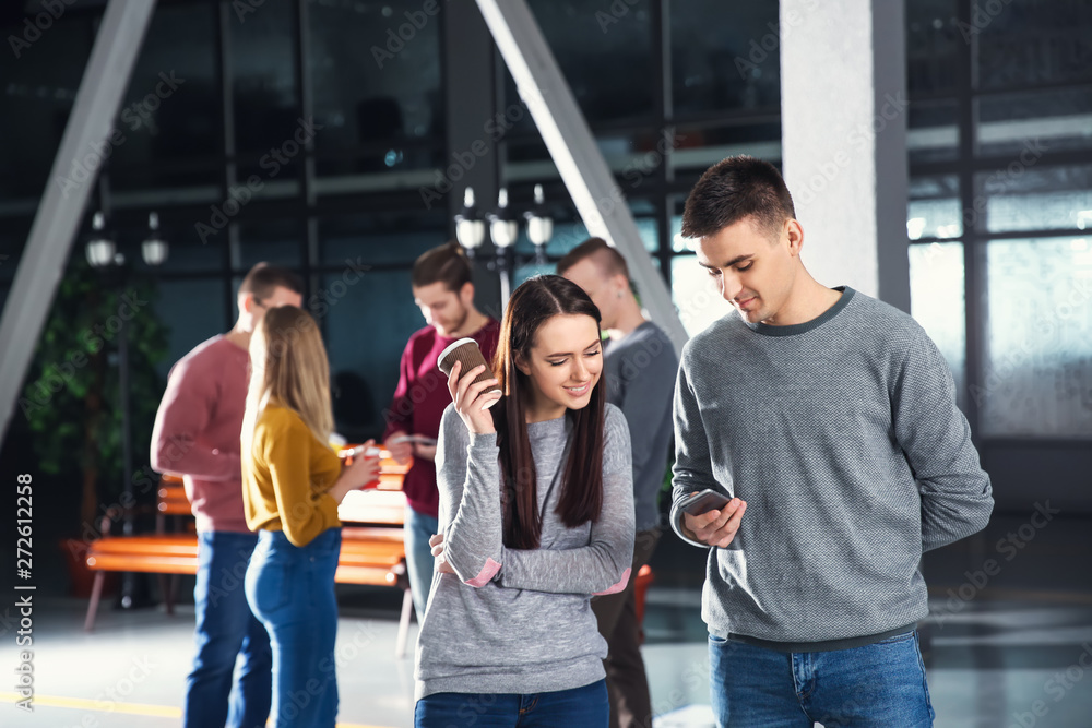 Young colleagues in lobby during coffee break