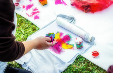 Creating your own t-shirt workshop. Young woman hand painting on