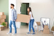 © Pixel-Shot - Young couple with big box in their new house