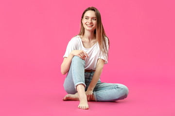 Wall Mural - Stylish young woman in jeans on color background