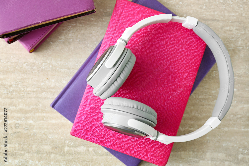 Books and modern headphones on table. Concept of audiobook