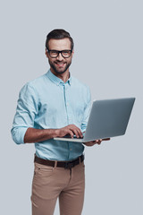 looking for fresh ideas. good looking young man carrying laptop and looking at camera while standing