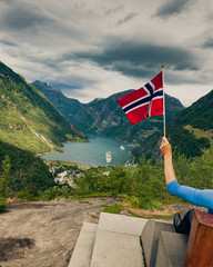 Sticker - Tourist over Geirangerfjord holds norwegian flag