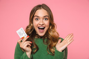 Wall Mural - Surprised happy woman wearing in green sweater holding credit card