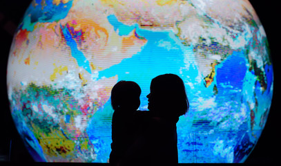 silhouette of adult and child on background of globe earth