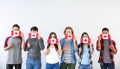 Wall Mural - Group of students with Canadian flags on light background