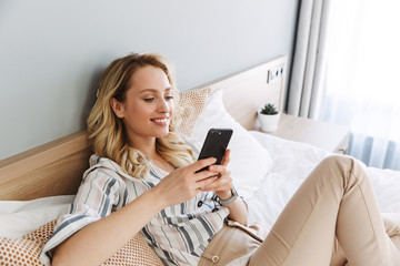 Poster - Beautiful young blonde woman relaxing in bed