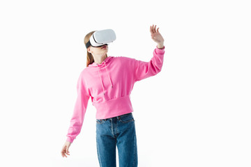 Wall Mural - teenage girl in pink hoodie and jeans wearing vr headset and gesturing isolated on white