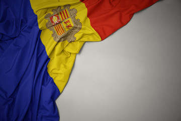 waving national flag of andorra on a gray background.