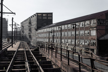 Wall Mural - View down railroad tracks alongside abandoned industrial buildings, horizontal aspect