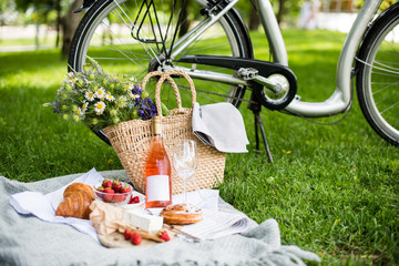 Wall Mural - Beautiful summer picnic with strawberries, cheese and rose wine on the lawn in the city park