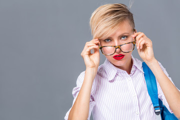 Wall Mural - Beautiful woman with short hair and glasses wearing shirt and holding bag	