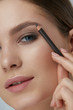 © puhhha - Eyebrow makeup. Beauty model shaping brows with brow pencil