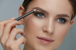 Beauty makeup. Woman shaping eyebrow with brow pencil closeup